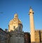 The Basilica of Ulpia and the column of Trajan in Rome in the evening rays of the setting sun.