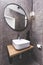 Basin and round mirror in a modern new luxury bathroom