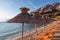 Baska - Straw umbrellas and loungers on idyllic pebble beach in resort town Baska, Krk Otok, Primorje-Gorski Kotar, Croatia