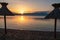 Baska - Straw umbrellas at sunset on idyllic pebble beach in tourist resort town Baska, Krk Otok, Primorje-Gorski Kotar