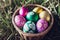 A basket brimming with vibrant Easter eggs rests gracefully amidst the green meadow.