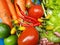 Basket of colourful vegetables with carrots, tomatoes, red chillis, beans, broccoli, and lettuces