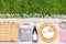 basket, crockery and wine bottle on picnic blanket