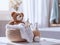 A basket with delicate baby cosmetics, fluffy towels and other bath accessories and a cute stuffed animal on a small table in a