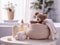 A basket with delicate baby cosmetics, fluffy towels and other bath accessories and a cute stuffed animal on a small table in a