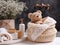 A basket with delicate baby cosmetics, fluffy towels and other bath accessories and a cute stuffed animal on a small table in a