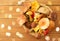 Basket of different edible mushrooms on wood