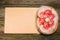 Basket with Easter red eggs on vintage sheet of paper on the right side of wood table. Top view horizontal background