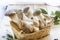 Basket with eryngii mushrooms and ingredients for cooking on the wooden table of the kitchen background