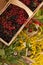 A basket filled with ripe berries and a bouquet of filed flowers on a wooden surface decorated with hips and autumn leaves