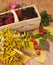 A basket filled with ripe berries and a bouquet of filed flowers on a wooden surface decorated with hips and autumn leaves