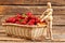 Basket filled with strawberries on wooden boards.