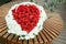 Basket of flowers on wooden bench. heart shape of red roses