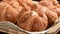 Basket of fresh croissants set out by a coffee serving area