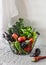 Basket with fresh organic garden seasonal vegetables - kale, eggplant, tomatoes, zucchini, lettuce, pepper on a light background.