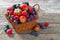 basket of fresh seasonal berries on wooden table, top view