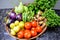 Basket full of different varieties of vegetables tomato lemon eggplant gourd taro ladyfinger bell pepper mint coriander.