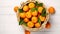 Basket full of fresh whole juicy clementine oranges with leaves on white wooden textured table. Generative AI