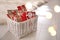 Basket full of gifts in paper bags for Christmas advent calendar on floor, space for text