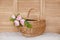 Basket with peony flowers on a wooden background