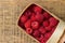 Basket with raspberries on wooden background