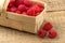 Basket with raspberries on wooden background