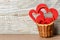 Basket with red hearts against wooden background as a Valentine\'