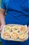 A basket of six quiches held by man in blue apron