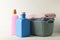 Basket with towels and bottles with laundry liquid on white wooden table