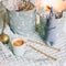 Basket with toys, yarn, needles, knitted clothes against bokeh lights background. Cozy nursery interior. Winter or Christmas mood