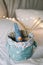 Basket with toys, yarn, needles, knitted clothes against bokeh lights background. Cozy nursery interior. Winter or Christmas mood
