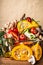 Basket with various autumn seasonal organic harvest vegetables and pumpkin at wall background, front view. Autumn food