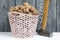 A basket with walnuts. There is a hammer nearby. Against the background of painted pine boards