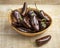 Basket with whole fresh chocolate mini pointed bell peppers close up