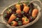 Basket with whole fresh orange and chocolate mini pointed bell peppers close up