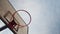 Basketball ball flying into a basketball hoop. View from under the basketball basket. Blue sky background. Basketball