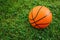 Basketball ball on a fresh green grass. Outdoor kids playground
