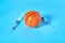 Basketball ball near syringe on blue background. Concept of doping in professional sport