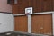 Basketball board and hoop net fixed on the wall of family house over two garages.