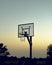 Basketball court illuminated by the glowing sun in the twilight sky