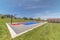 Basketball court pavilion and playground at a park under blue sky on a sunny day