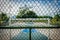 Basketball court and soccer field in public park behind fence -