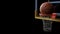 Basketball going into hoop on black isolated background. Sport a
