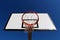 Basketball hoop against blue sky in a playground seen from under the rim