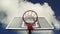 Basketball hoop with cage with clouds time lapse footage in background.