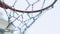 Basketball hoop with metal net outdoors. Orange ball flying in ring. Score in outdoor competitive game.