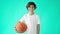 Basketball for kids. Portrait of active teenage boy in white t-shirt holding basketball ball, looking at camera and