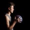 Basketball player holding ball on black