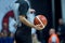 Basketball referee holding a basketball at a game in a crowded sports arena