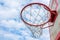 A basketball ring at the background of the sky with clouds. Side view. Hoop